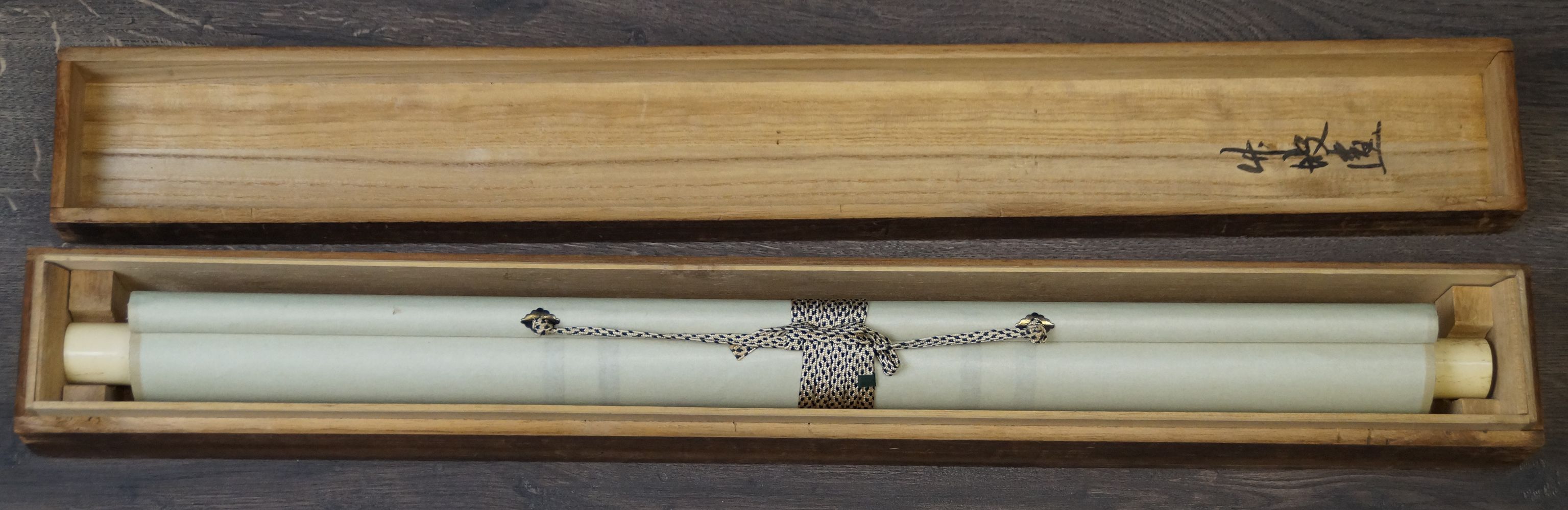 Rolled-up Kakemono Sparrows on a Fruit Tree with ivory-colored scroll ends in the opened storage box