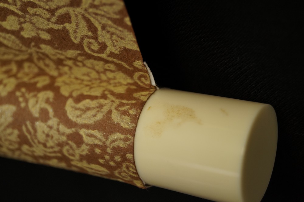 Elfenbeinfarbenes Rollenende und Seidenbrokat Rollendetail