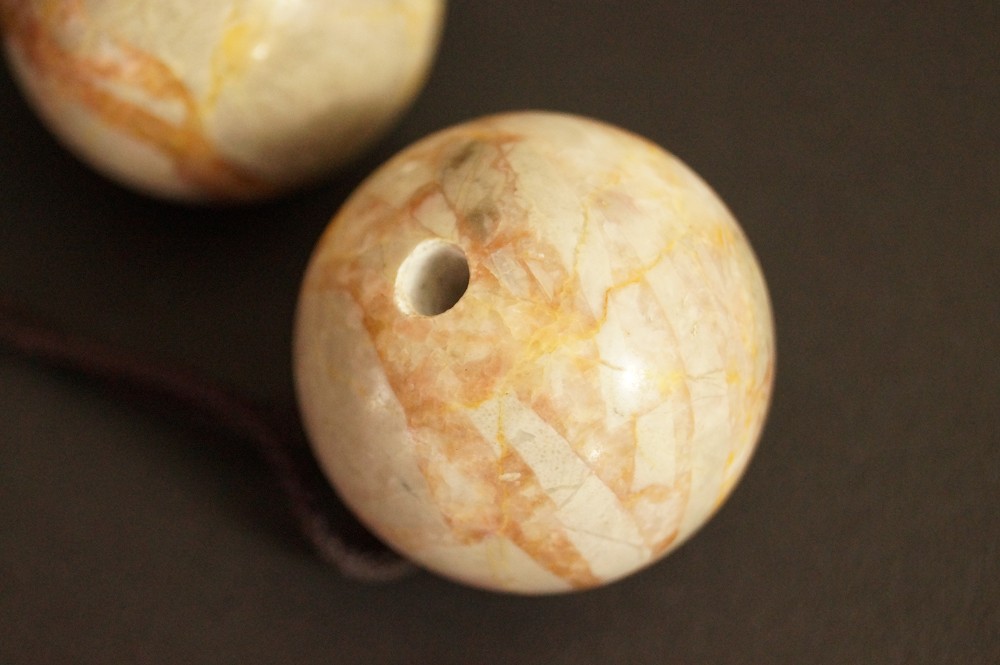Orange Marbled Stone Sphere with Drilled Hole in Close-Up Stone Close-Up 2