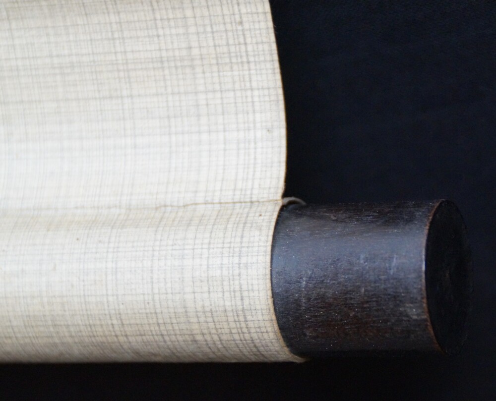 Close-up of the dark scroll end with cream-colored silk in the kakemono Raven on a Bare Branch by Watanabe Ando