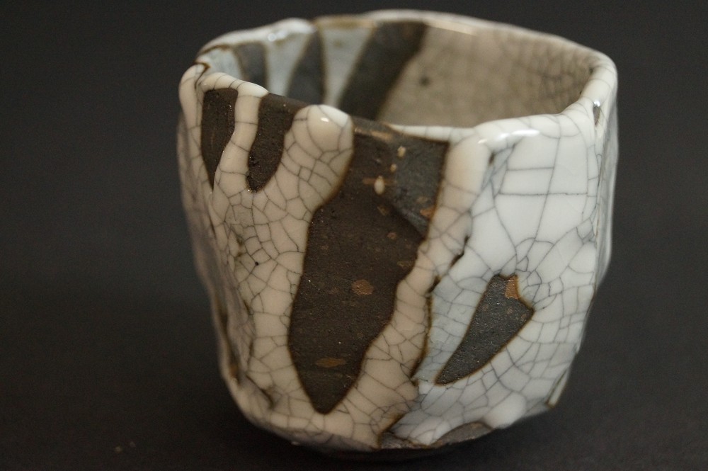 Shino sake cup from the back with irregular rim shape back view