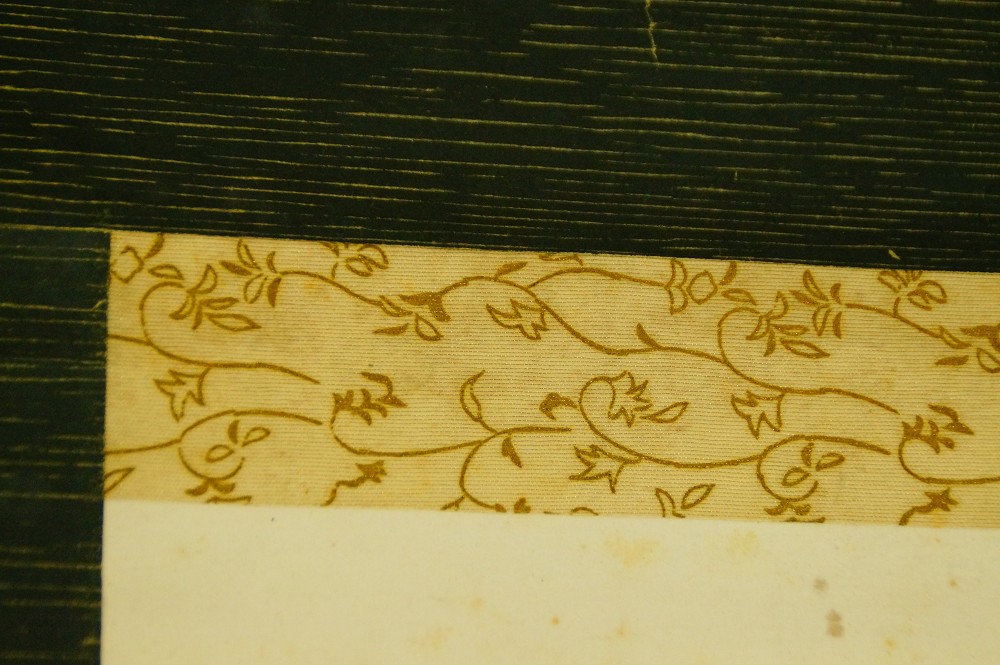 Close-up of the gold-patterned border on dark green silk