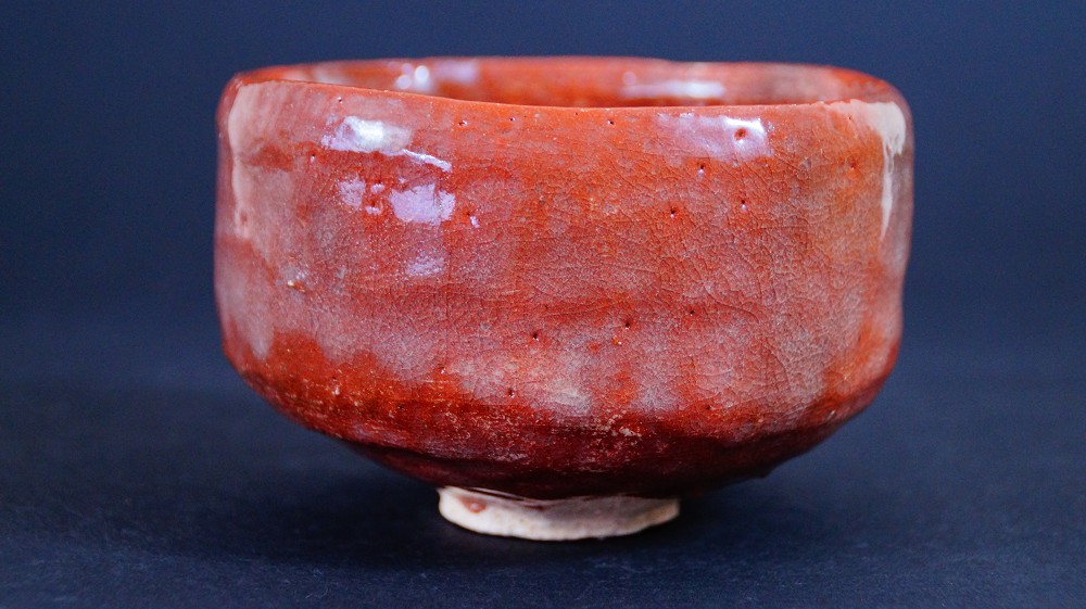 Further side view of the chawan made of Raku ware by Sairi Hotoku with irregular rim