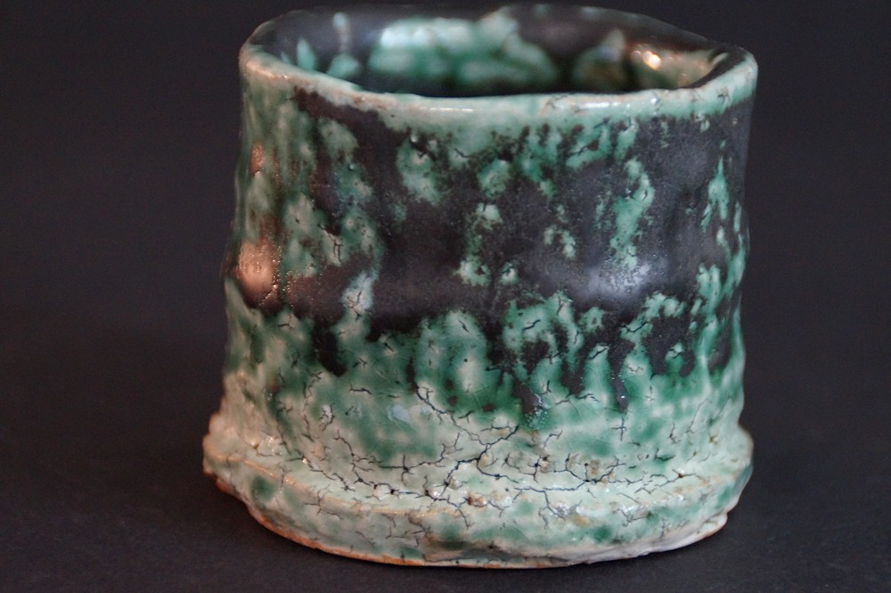 Back view of the sake cup with dark green-black mottled crackle glaze
