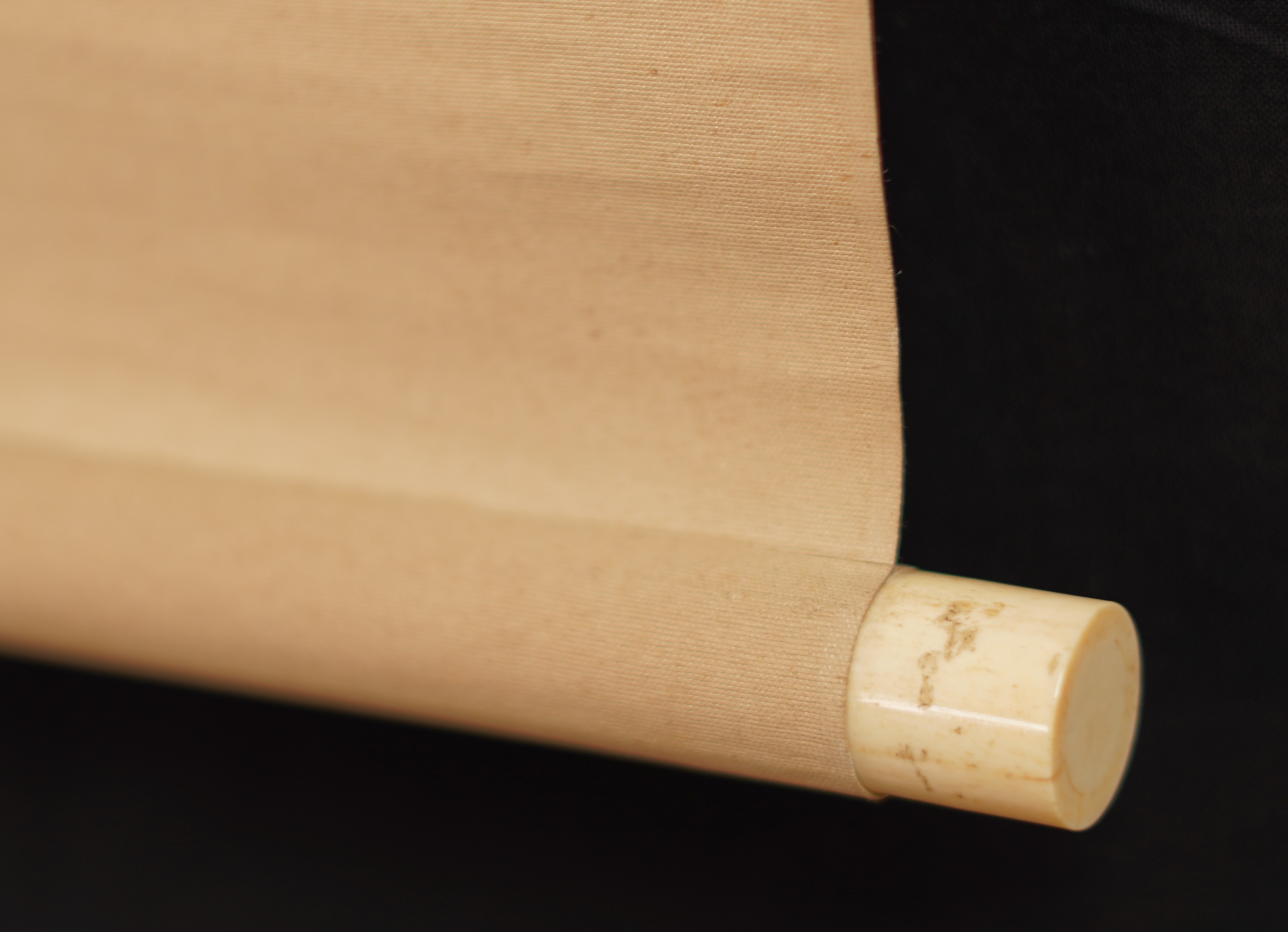 Detail view of the scroll end with ivory knob and cream-colored silk of the Kakemono Hanging Cherry Blossoms