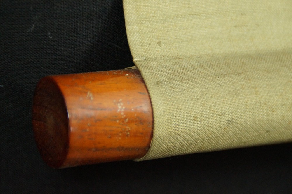 Close-up of the reddish-brown wooden scroll end