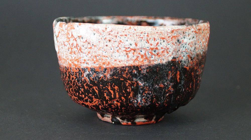 Chawan tea bowl made of Raku ware by Ryohei Kusakabe, full view with red-black glaze