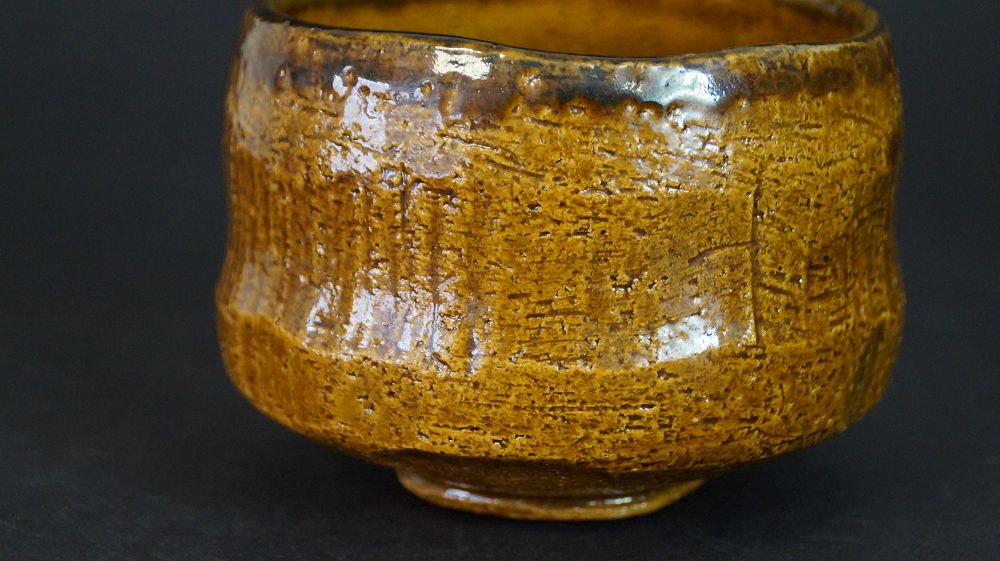 Additional view of the chawan made of Raku ware with dark speckled glaze rim