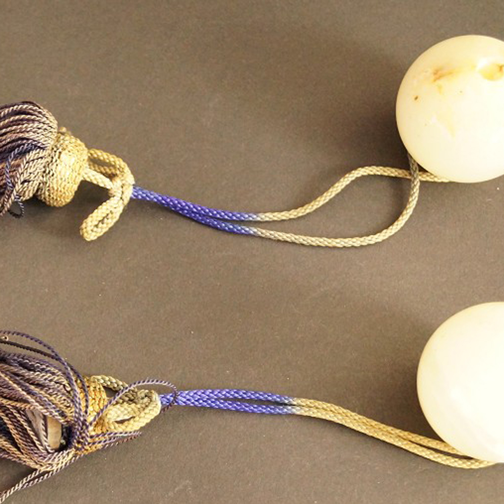 Two Light-Colored Natural Stone Balls with Purple-Gold Silk Tassels Set Close-Up Preview
