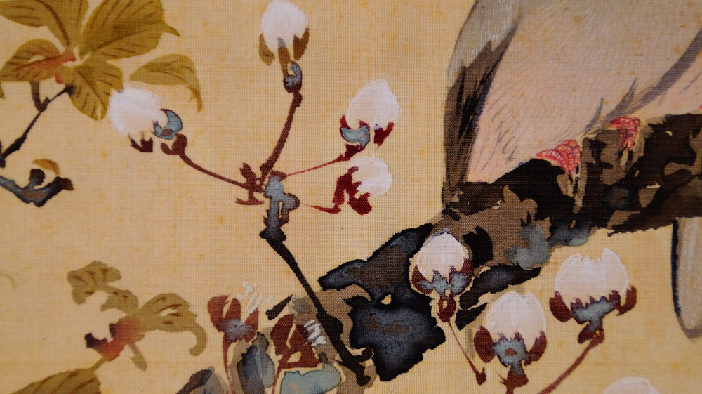 Close-up of the reddish buds and blossoms with a detail of the bird's plumage in the hanging scroll Spring Awakening Two Birds on a Blooming Cherry Branch