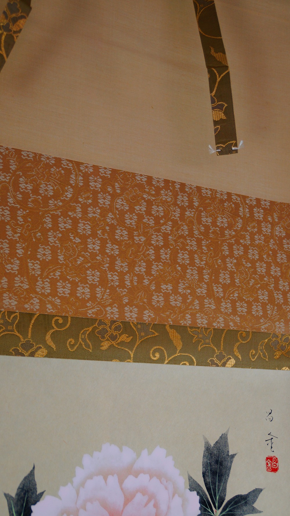 Detail of the upper mounting of the hanging scroll with golden vine brocade