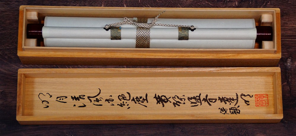 Rolled-up kakemono with cord tie in the storage box with inscribed lid
