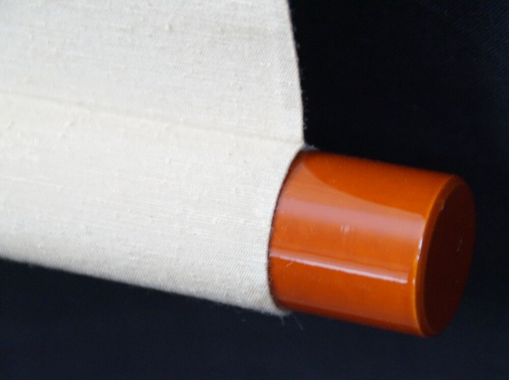 Detail view of the scroll end with amber-colored knob and cream-colored silk of the Kakemono Pale Pink Plum Blossoms in Spring Light
