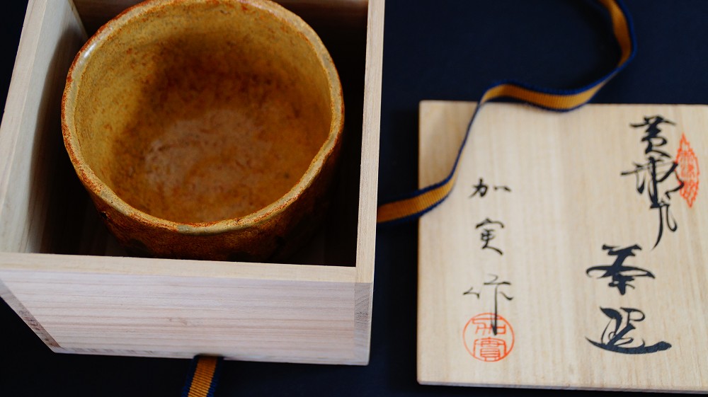 Chawan made of Seto ware by Takamichi Kato next to the opened lid of the storage box with ink inscription and red artist's seal