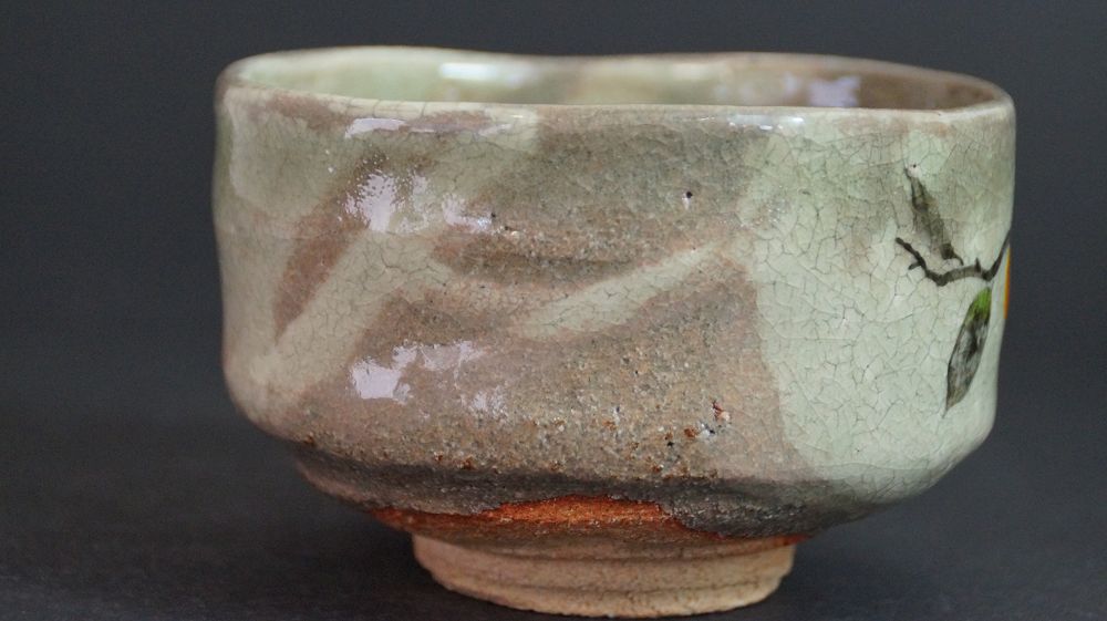 Further view of the chawan made of Kyoto ware with the transition from the back to the persimmon branch motif