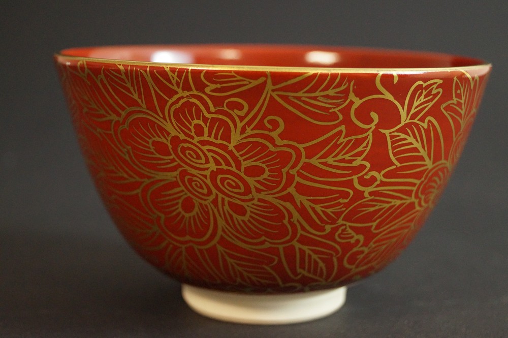 Red tea bowl with golden peony motif front view