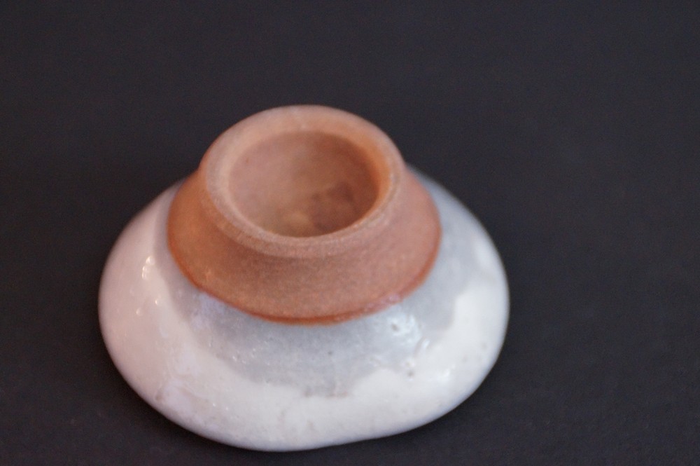 Close-up of the unglazed foot with reddish clay body