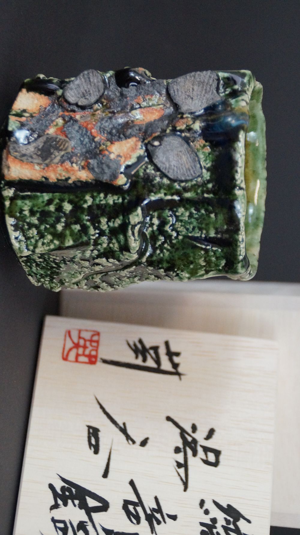 Yunomi tea cup made of Oribe ware next to the signed storage box with red artist's seal