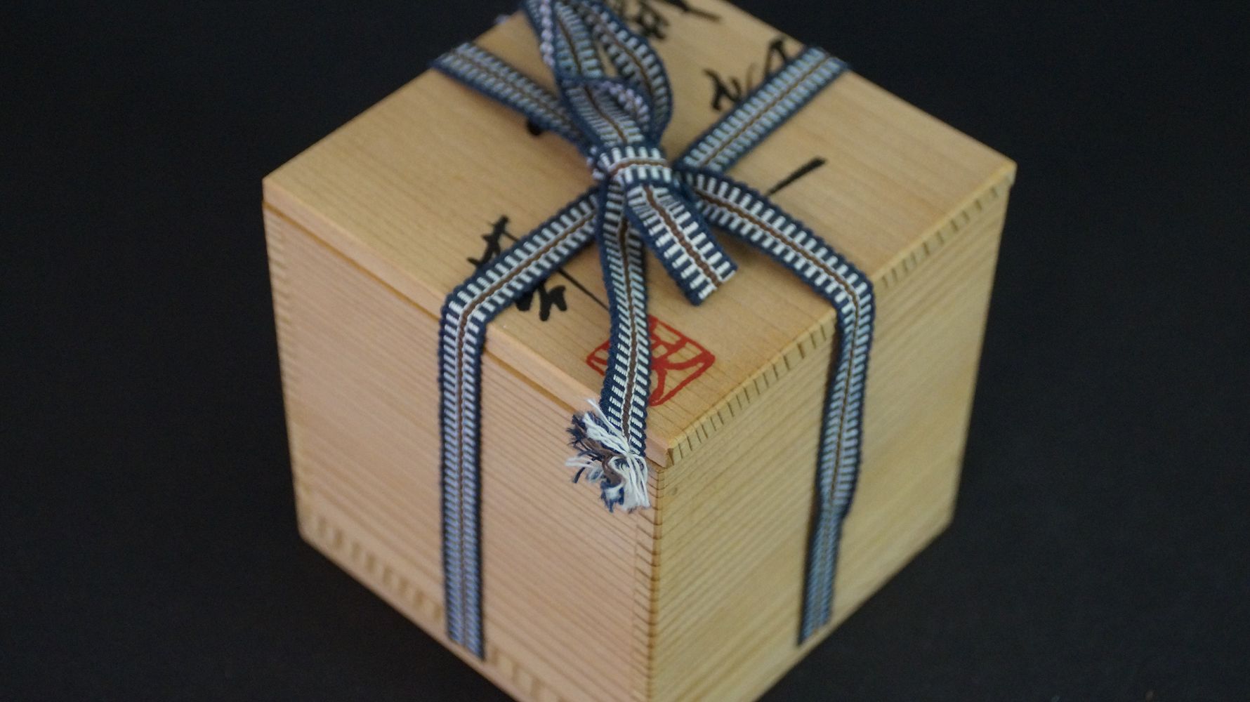 Closed storage box tied with striped cord, for the Guinomi sake cup made of Oribe ware
