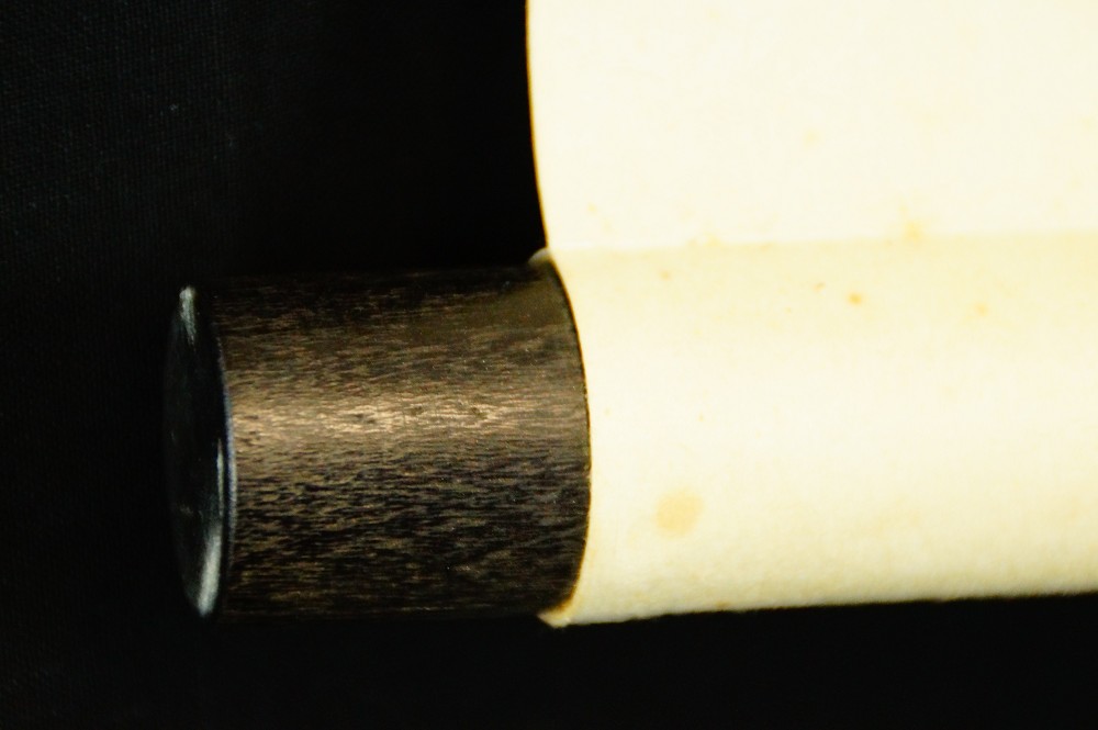 Close-up of the dark wood jikusaki at the end of the hanging scroll