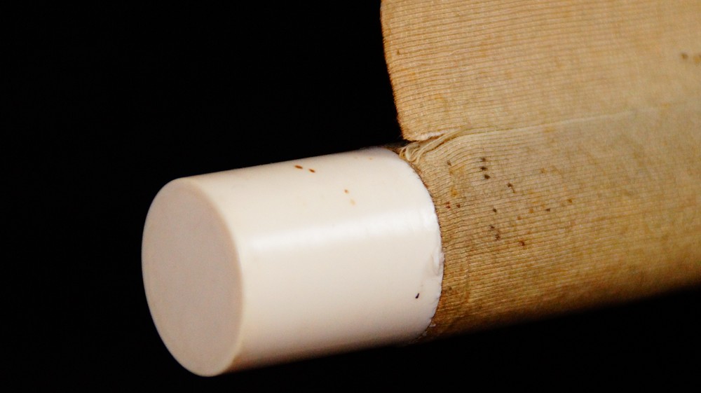 Close-up of the white roller end at the opposite end of the kakemono