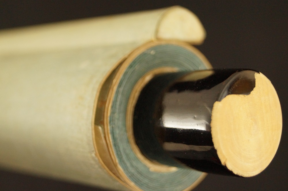 Textilrand und schwarz lackierter Holzstab Rollenende Rollendetail