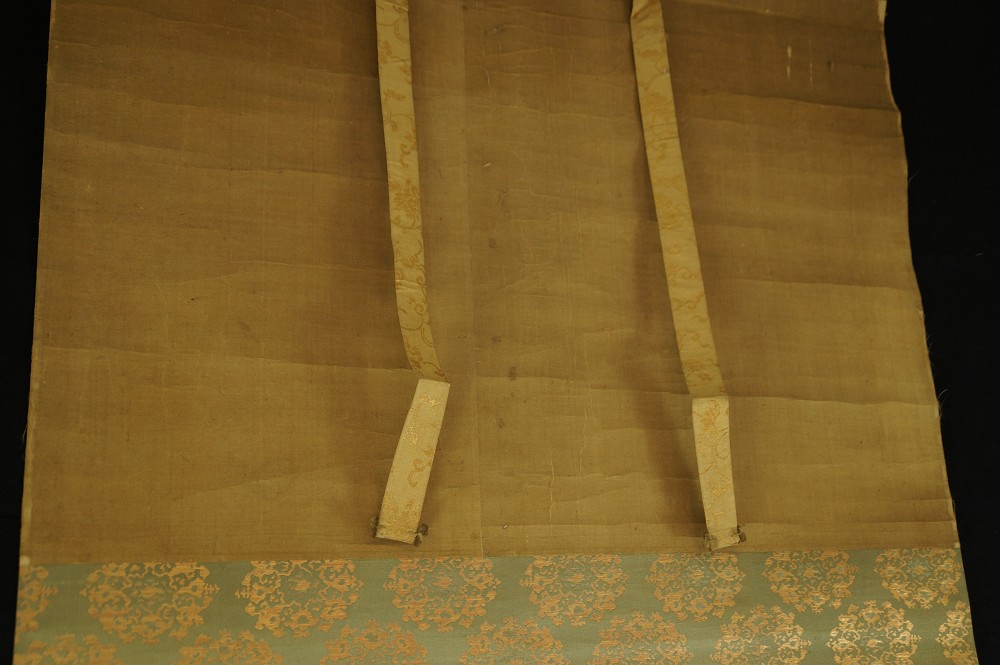 Close-up of the silk hanging cords and the blue-green mounting