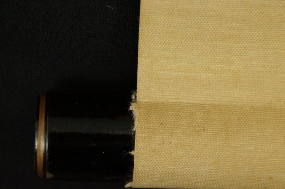 Close-up of the dark lacquered jikusaki at the end of the scroll