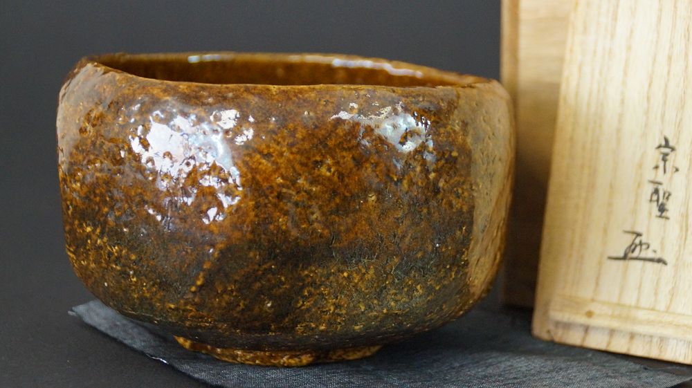 Chawan Teeschale aus Raku-Keramik neben der signierten Aufbewahrungsbox