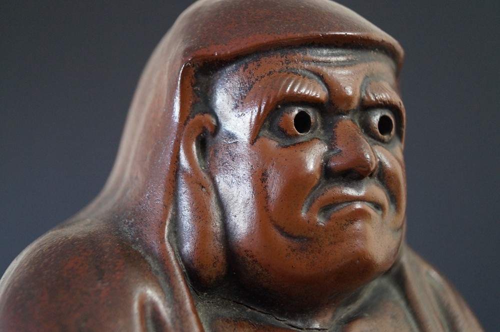 Daruma figure made of Bizen ware face close-up