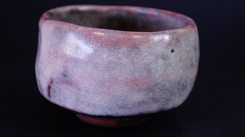 Side view of the chawan made of Ohi ware with reddish-brown and grayish-purple glaze by Kaihatsu Bunmei