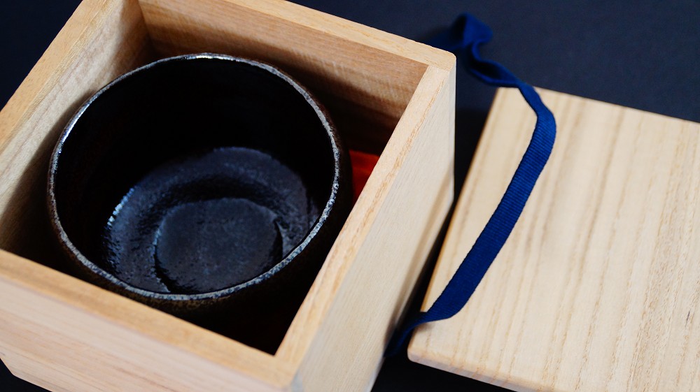 Chawan Made of Raku Ware by Shoraku Sasaki Lying in the Opened Storage Box with Dark Blue Cord