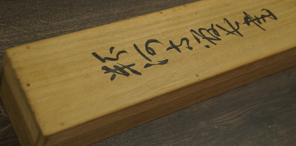 Close-up of the wooden storage box with ink inscription