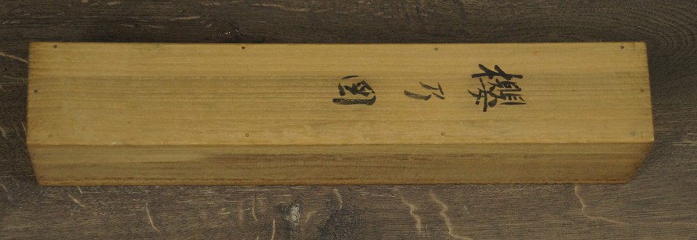Nahaufnahme der geschlossenen Aufbewahrungsbox mit handschriftlicher Titelbezeichnung