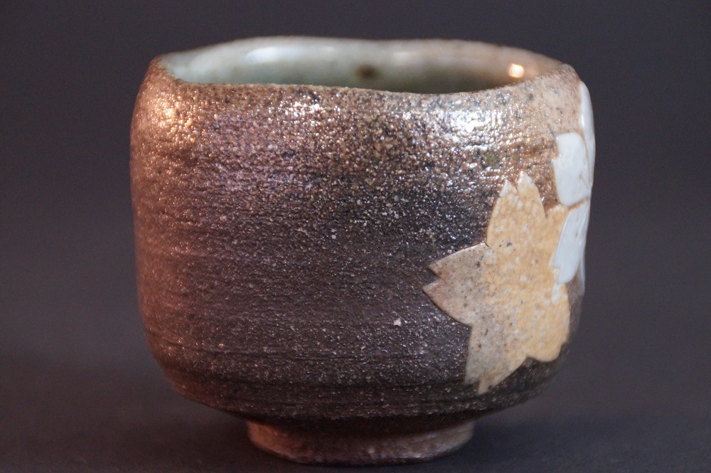 Further side view with iridescent glaze and visible cherry blossom motif