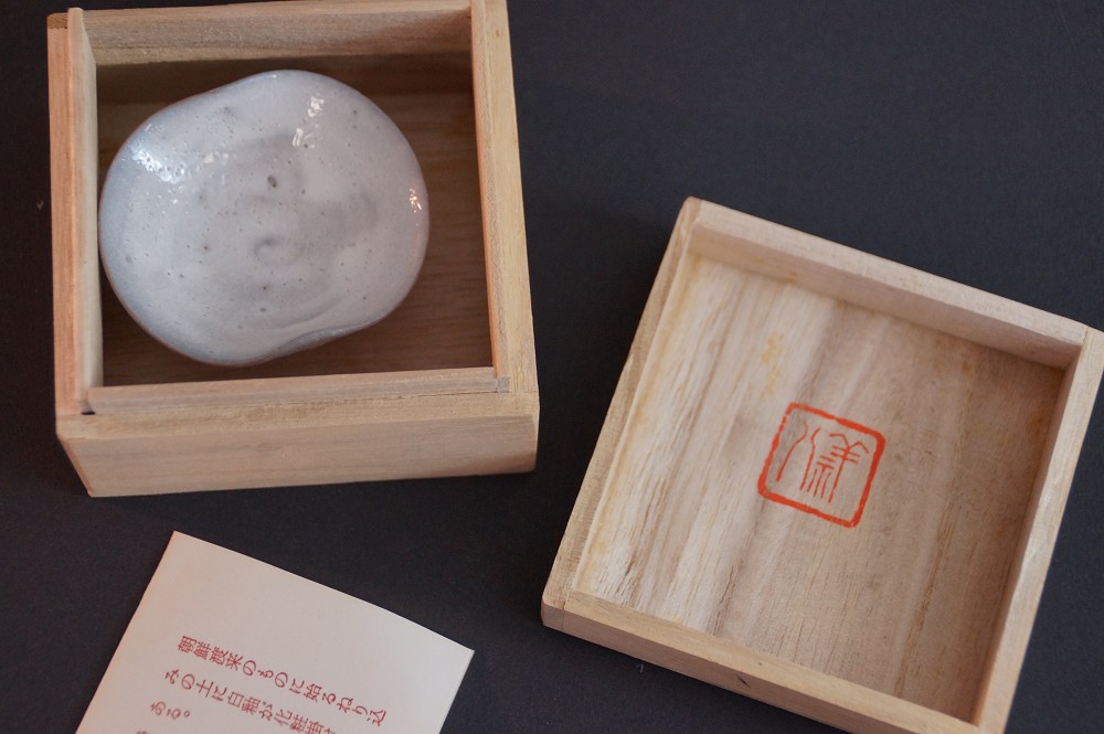 The guinomi lying in the opened storage box with certificate of authenticity
