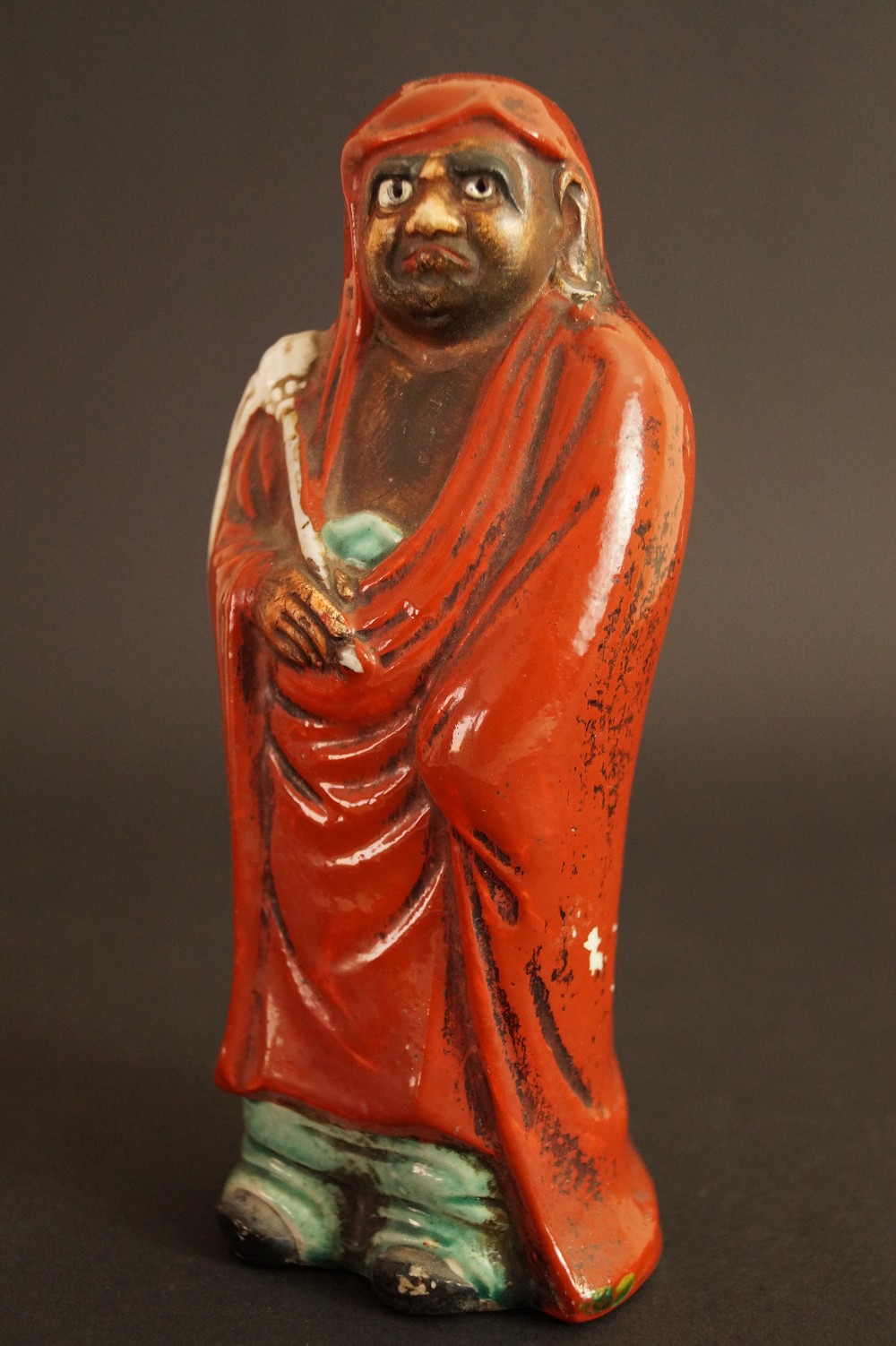 Bodhidharma Daruma figure made of red Kutani porcelain frontal view with view of hand and robe frontal view 2