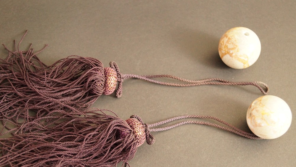 Two fuchin ornamental weights with mauve tassels set front view 1