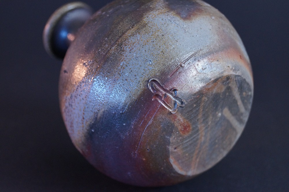 Close-up of the incised potter's mark on the shoulder of the tokkuri