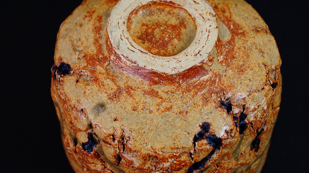 Close-up of the chawan's foot with deep firing cracks and light-colored foot ring of the Seto ware by Takamichi Kato