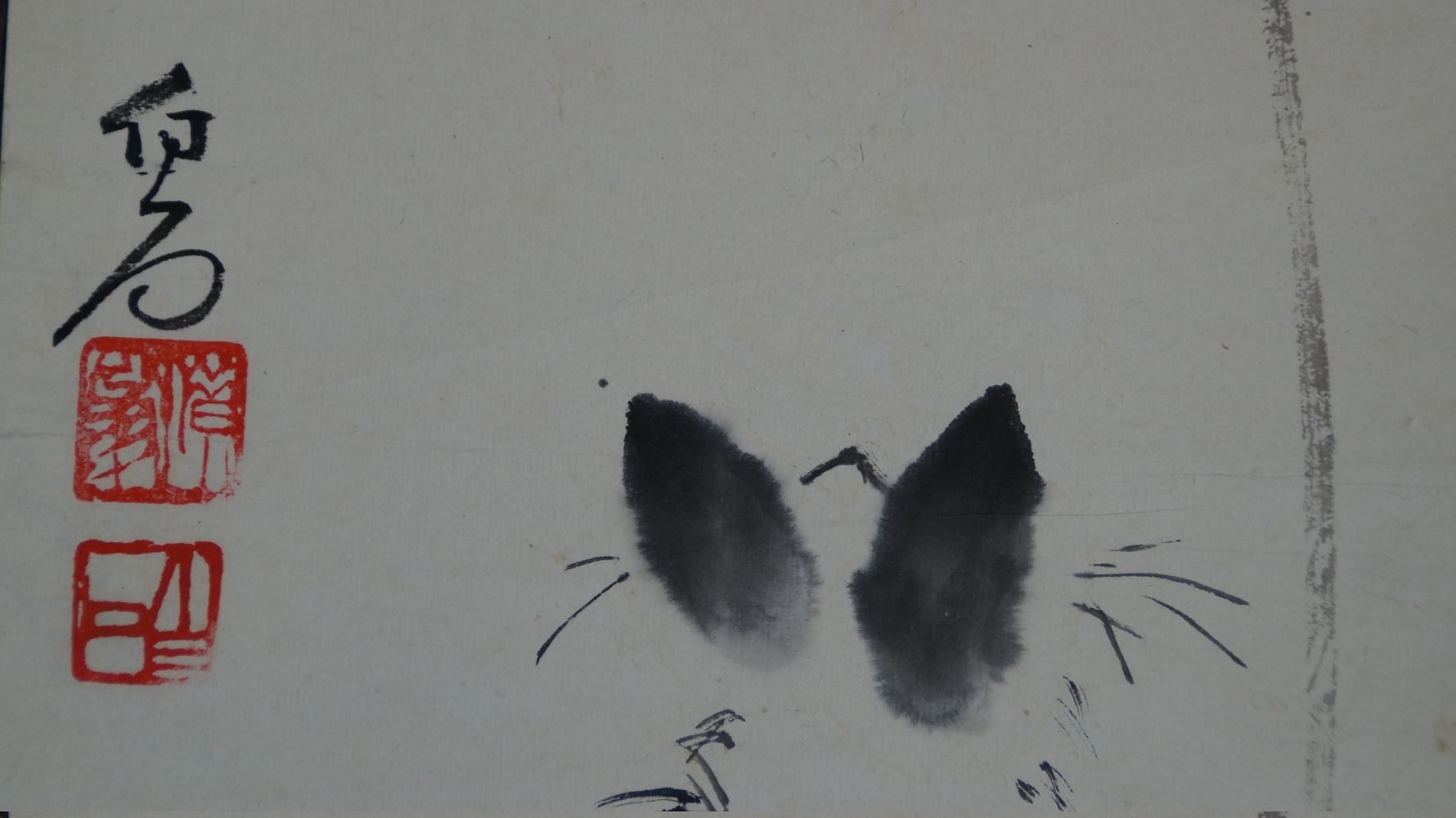 Further detail view of the artist's signature and the red seals next to the ears of the black cat