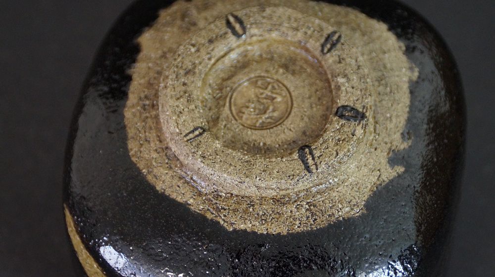 Detail view of the foot with impressed artist seal of the chawan made of Raku ware