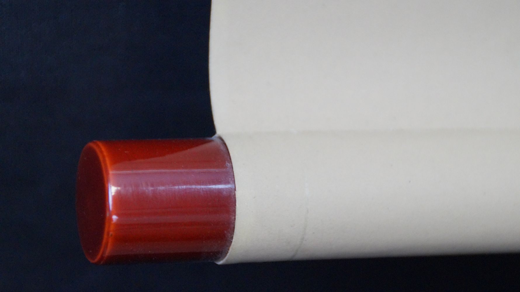 Detailansicht des roten Lackknaufs am Rollenende des Kakemono Banzai