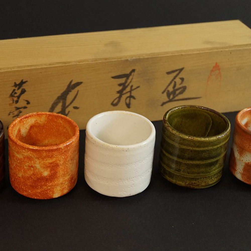 Four of the five Seto sake cups in front of a labeled storage box Motif Close-Up Preview