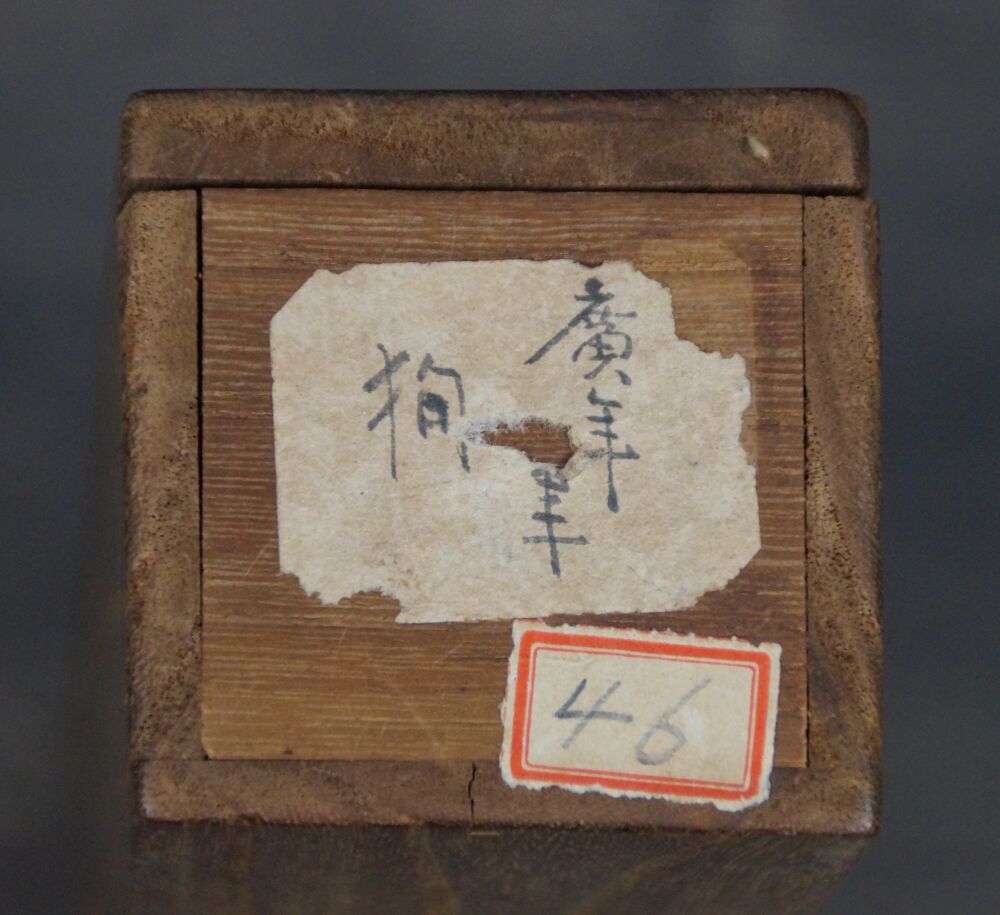 Deckel der Aufbewahrungsbox mit Kalligraphie-Beschriftung und Nummernetikett des Kakemono Welpe im Abendrot unter Kiefern