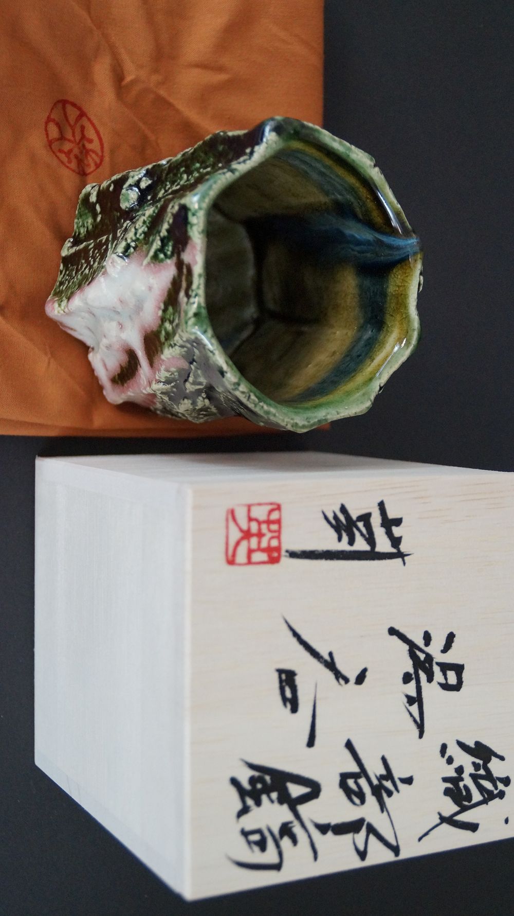 Yunomi Tea Bowl on Orange Cloth next to the Signed Box Lid with Red Artist Seal