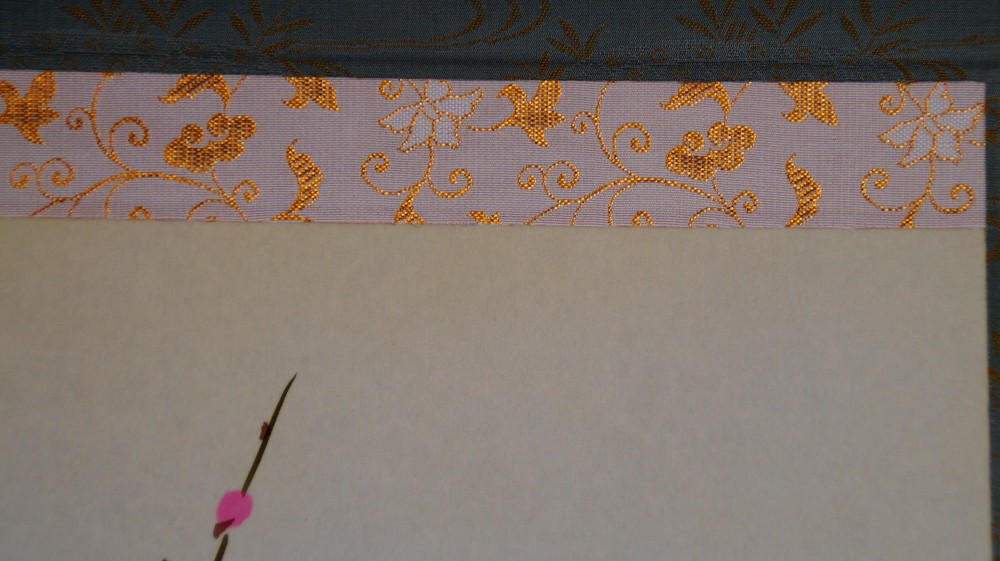 Detail view of the upper brocade mounting in the kakemono Heralds of Spring by Koizumi Kogetsu