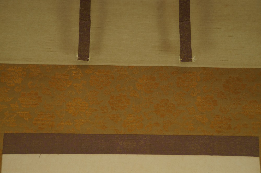 Close-up of the gold-brown border with blossom vine pattern