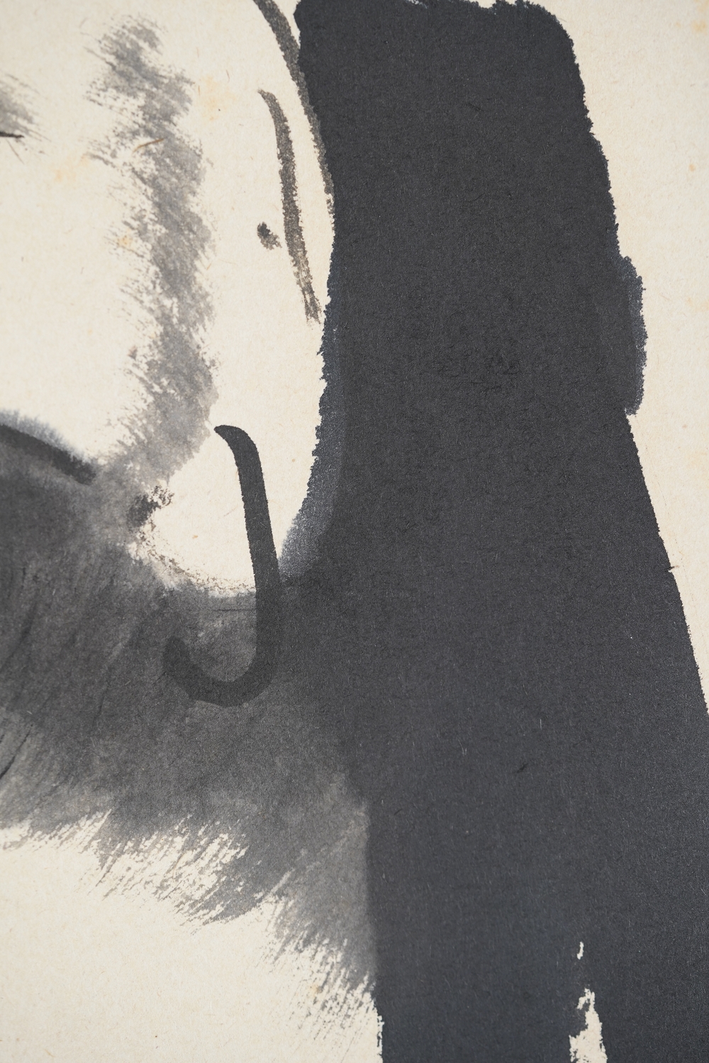 Detail view of the ear and hem of the robe of the Daruma painted in ink