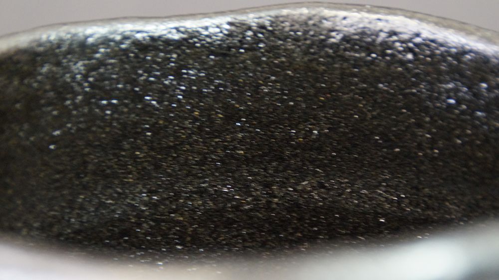 Close-up of the rim with finely speckled black glaze of the chawan made of Raku ware